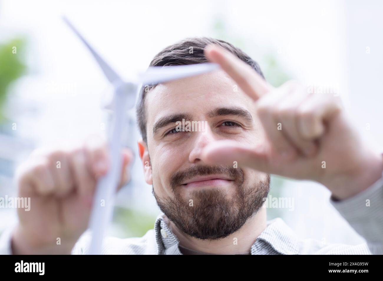 giovane uomo con il modello di mulino a vento in mano Foto Stock