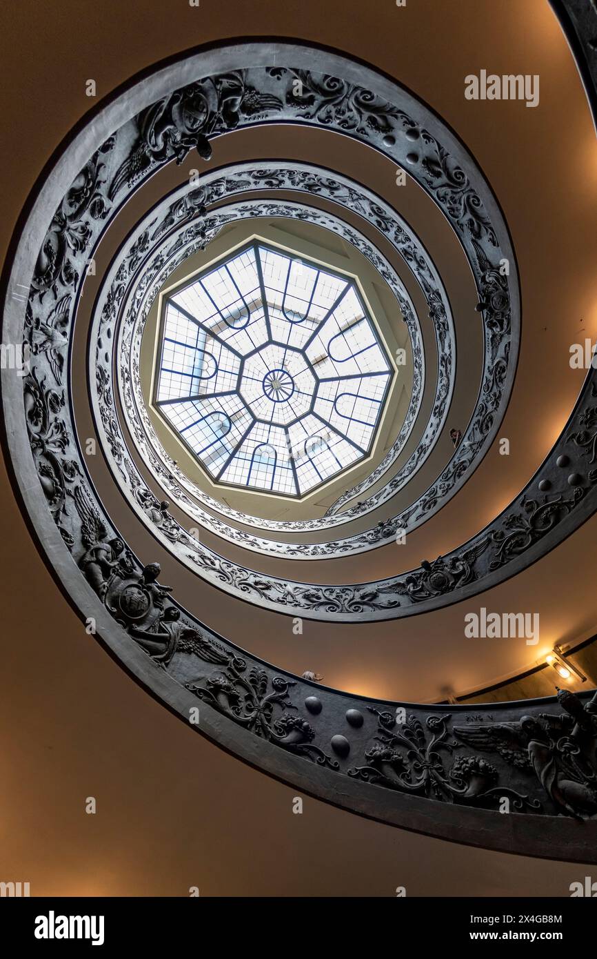 Scala a chiocciola con ringhiere in metallo ornato che conduce ad una finestra esagonale del lucernario. Elegante spirale per lucernario. Scala elicoidale Bramante Foto Stock