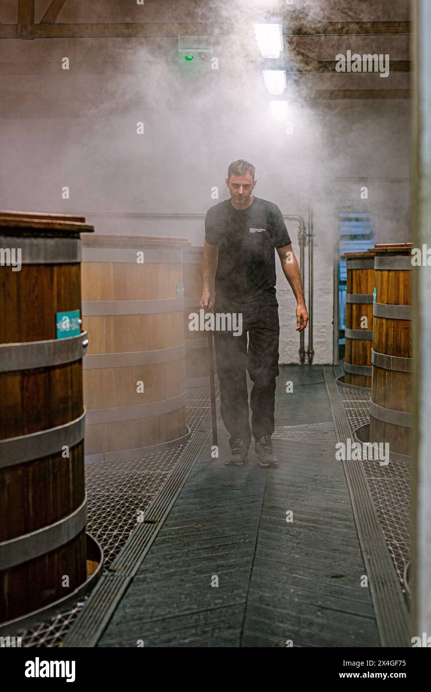Lavoratore della distilleria di whisky Bruichladdich che controlla la fermentazione ai washback, Isola di Islay, nelle Ebridi interne della Scozia. Foto Stock