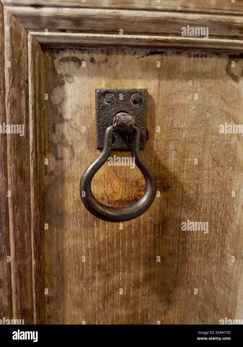 Un dettaglio di una vecchia maniglia di ferro su una porta di legno. Foto Stock