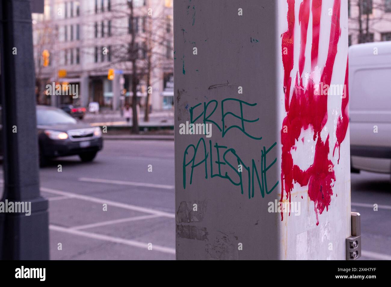 Uno slogan che chiede la liberazione della Palestina e una traccia di una mano sanguinosa nel centro di Toronto Foto Stock