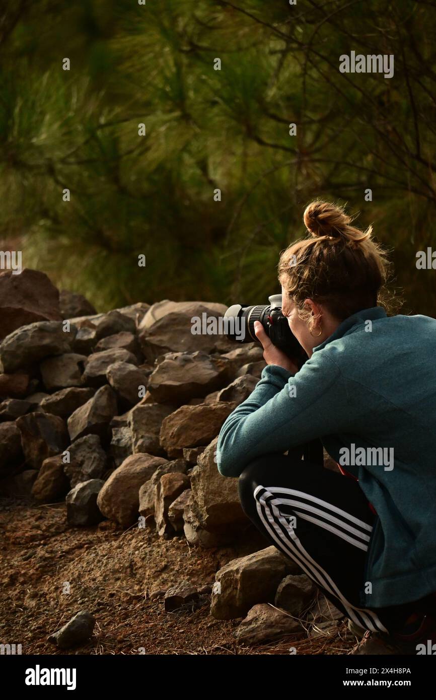 appassionata di fotografia, una giovane donna documenta l'ambiente naturale sereno, concentrandosi sull'acquisizione di momenti perfetti Foto Stock