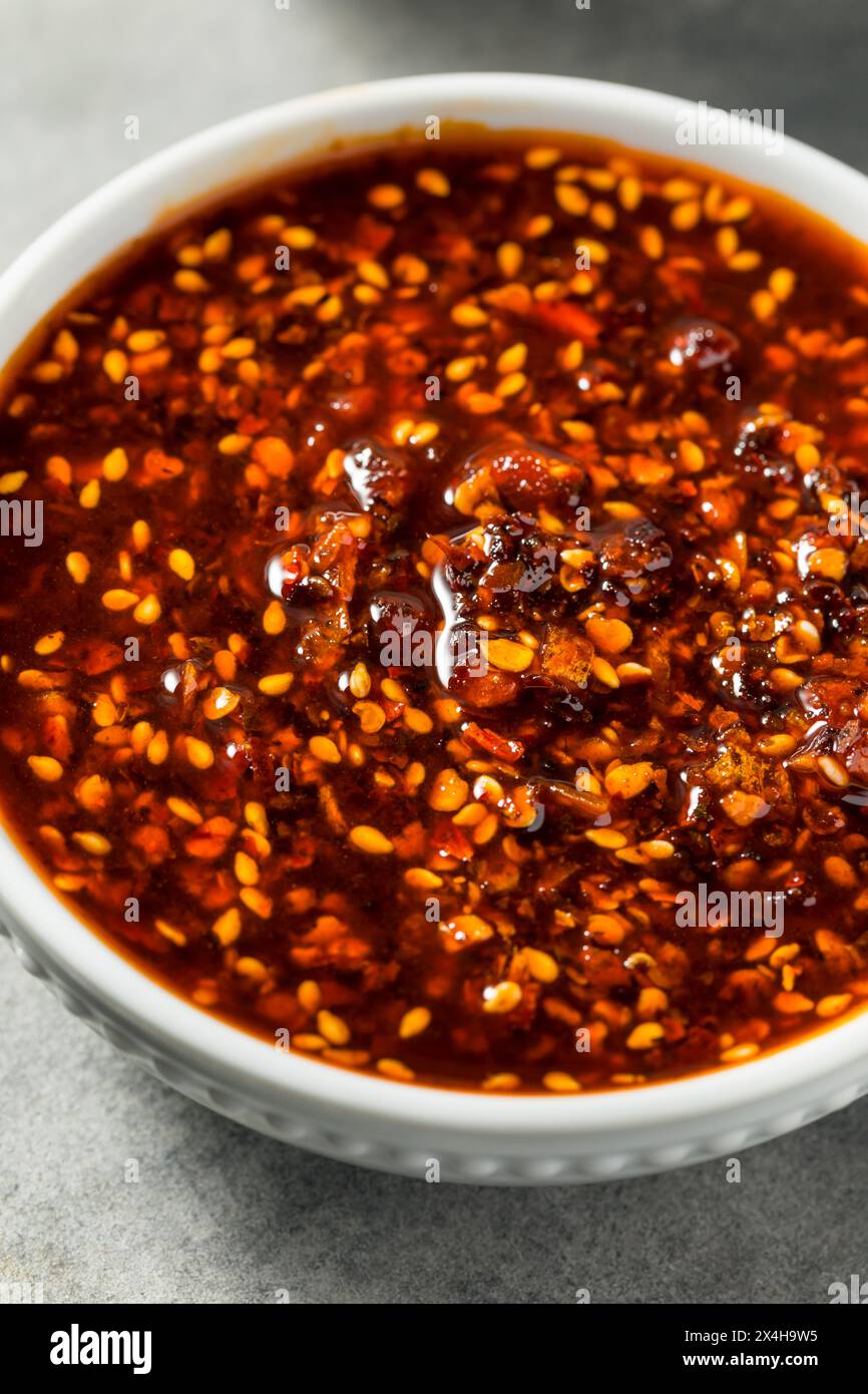 Olio piccante di peperoncino croccante in una ciotola Foto Stock