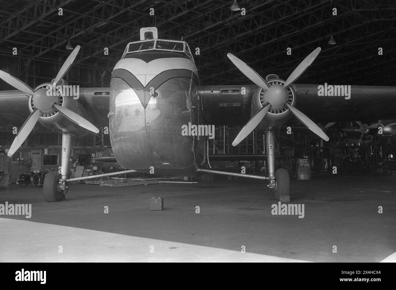 Inghilterra c.1957 – Una fotografia del Dan Air Bristol Type 170 Freighter Mk.31E, immatricolazione G-AINL parcheggiato all'interno di un hangar di manutenzione. Questo aereo, numero di serie, 012827, fu prodotto dalla Bristol Aeroplane Company Ltd nel 1947. È stato ottenuto da Dan Air nel luglio 1957 dalla Aviation Traders Ltd, avendo precedentemente prestato servizio con la Royal Air Force e Aer Lingus. Fu il primo di tre del suo tipo ad entrare in servizio con Dan Air. Foto Stock