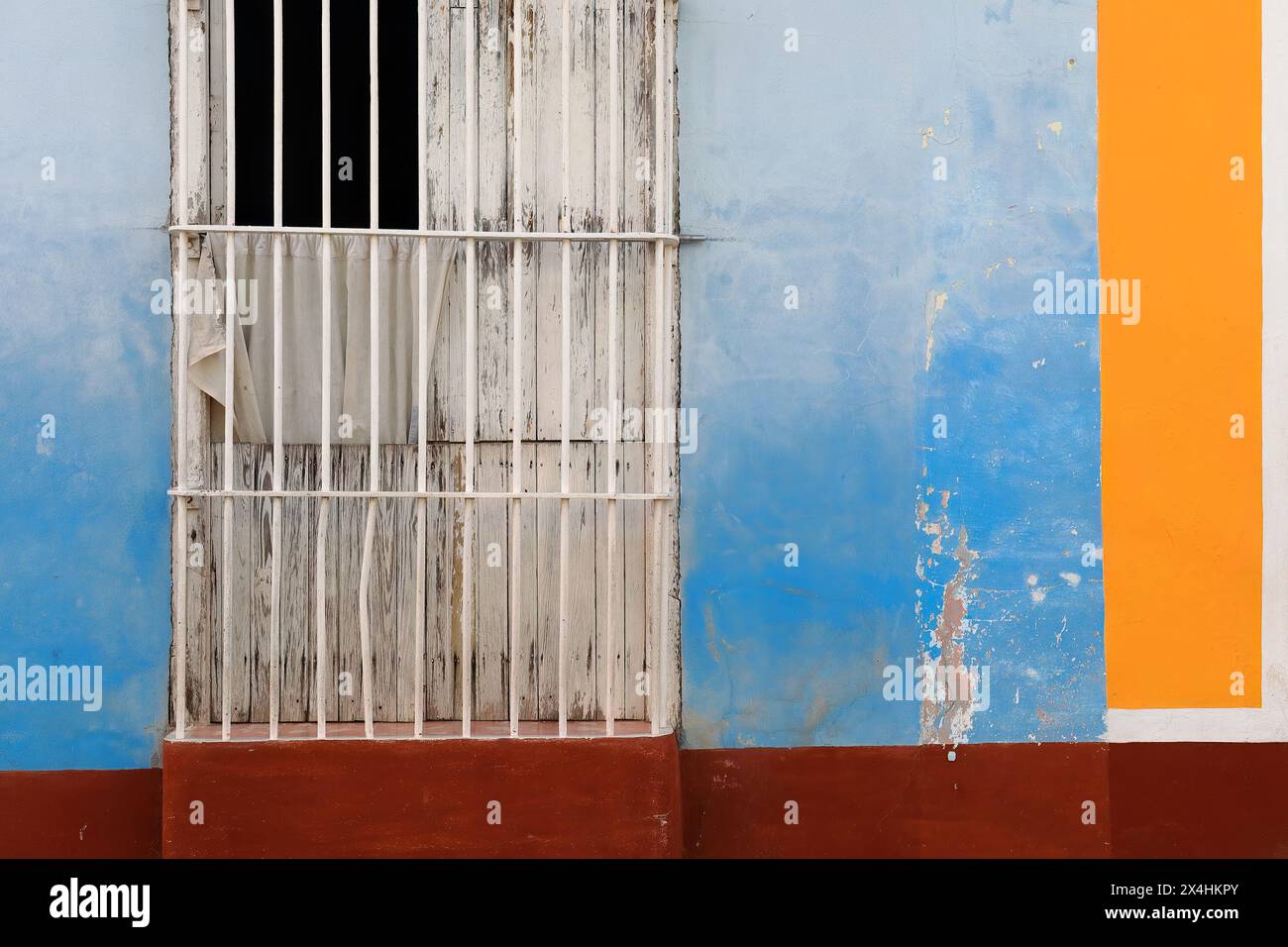 229 pareti colorate di casa coloniale che mostrano la solita finestra a griglia con persiane in legno e porte lunghe su una facciata blu-marrone-arancio-bianco. Trinidad-Cuba. Foto Stock
