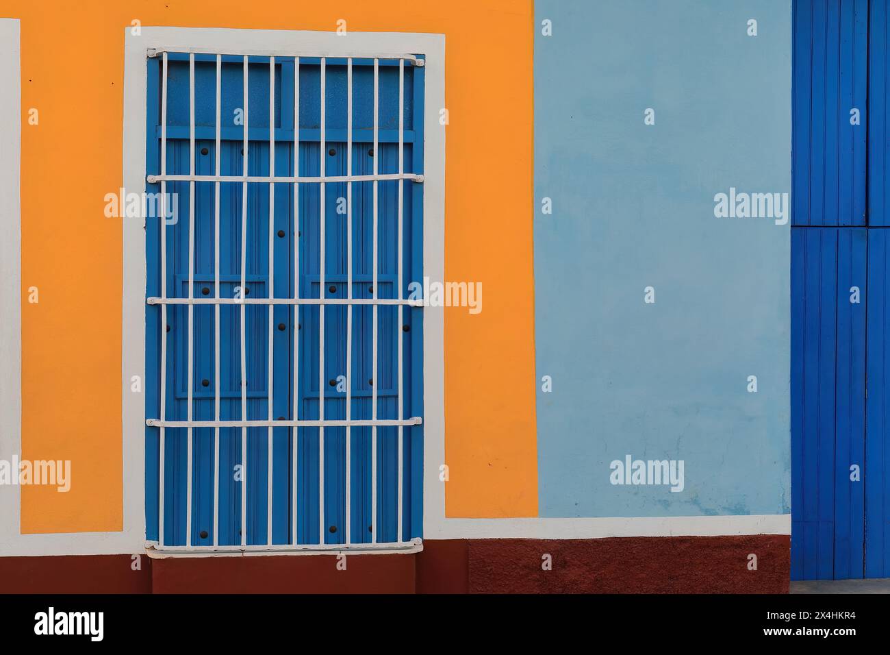 230 pareti colorate di casa coloniale che mostrano la solita finestra a griglia con persiane in legno e porte lunghe su una facciata blu-arancio-marrone-bianco. Trinidad-Cuba. Foto Stock