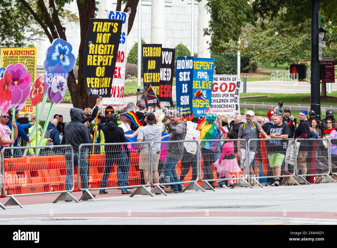 Atlanta, GA / USA - 15 ottobre 2023: Gli spettatori del gay Pride interagiscono con gli estremisti di destra mostrando segni omofobici durante la sfilata. Foto Stock