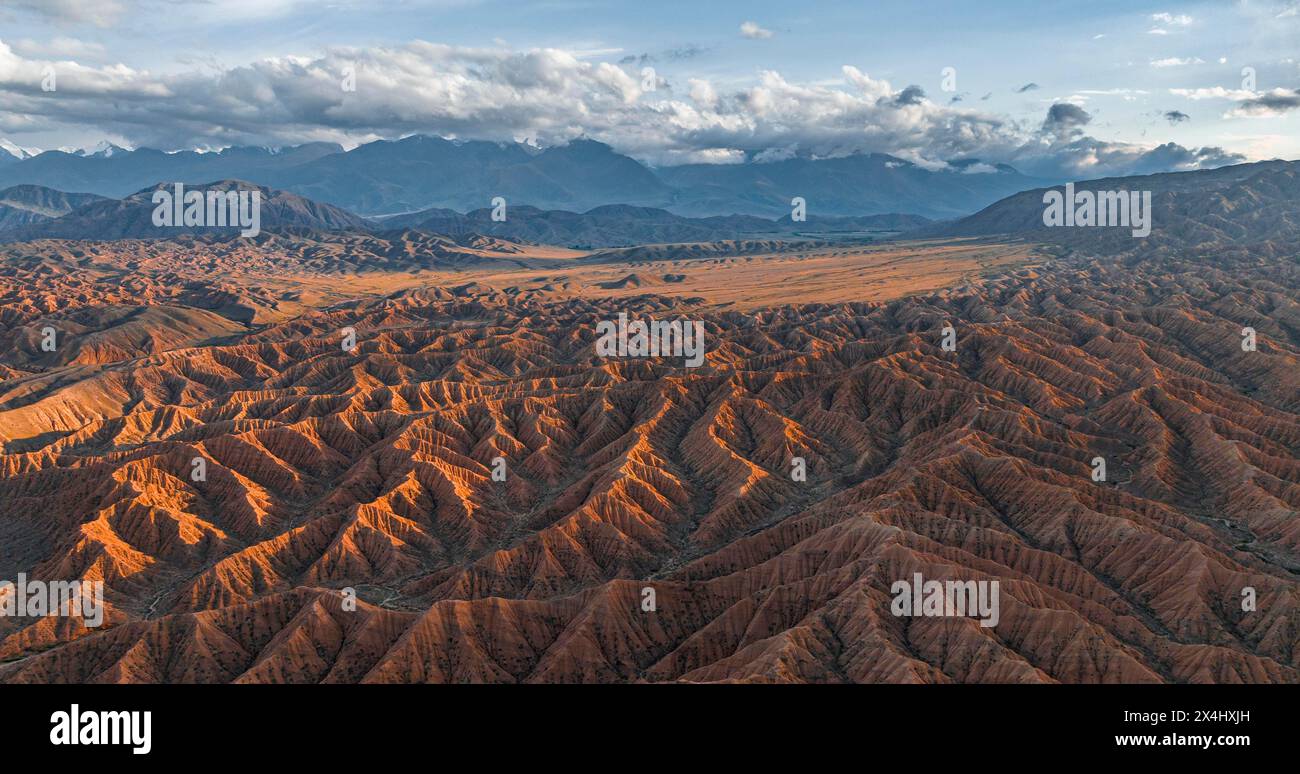 Atmosfera serale, cime delle montagne Tien Shan Mountains, suggestivo paesaggio arido di colline erose, Badlands, Canyon dei Forgotten Rivers Foto Stock
