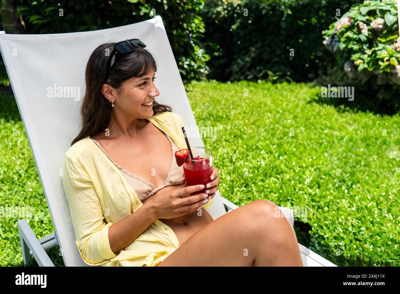 Bella donna che si rilassa su una poltrona con un succo di frutta in mano Foto Stock