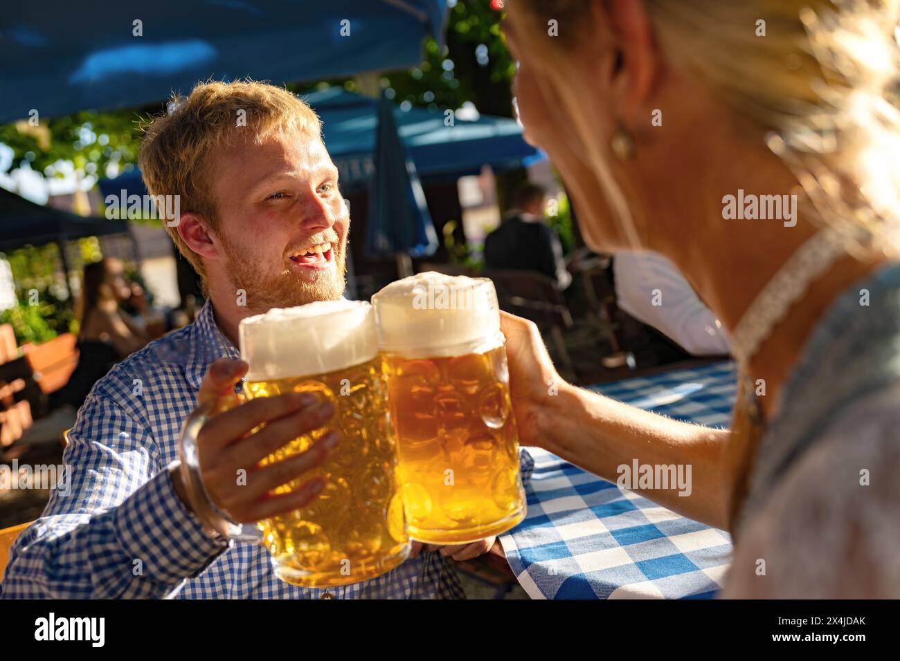 due persone che sorseggiano grandi tazze di birra all'oktoberfest in baviera Foto Stock
