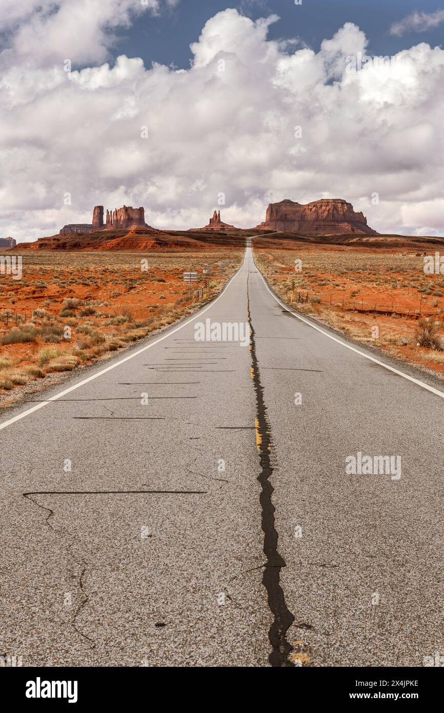 La vista della strada panoramica di Forrest Gump nella Monument Valley, Utah, durante una giornata nuvolosa mostra la lunga e solitaria strada che conduce in Arizona attraverso il famoso monte Foto Stock