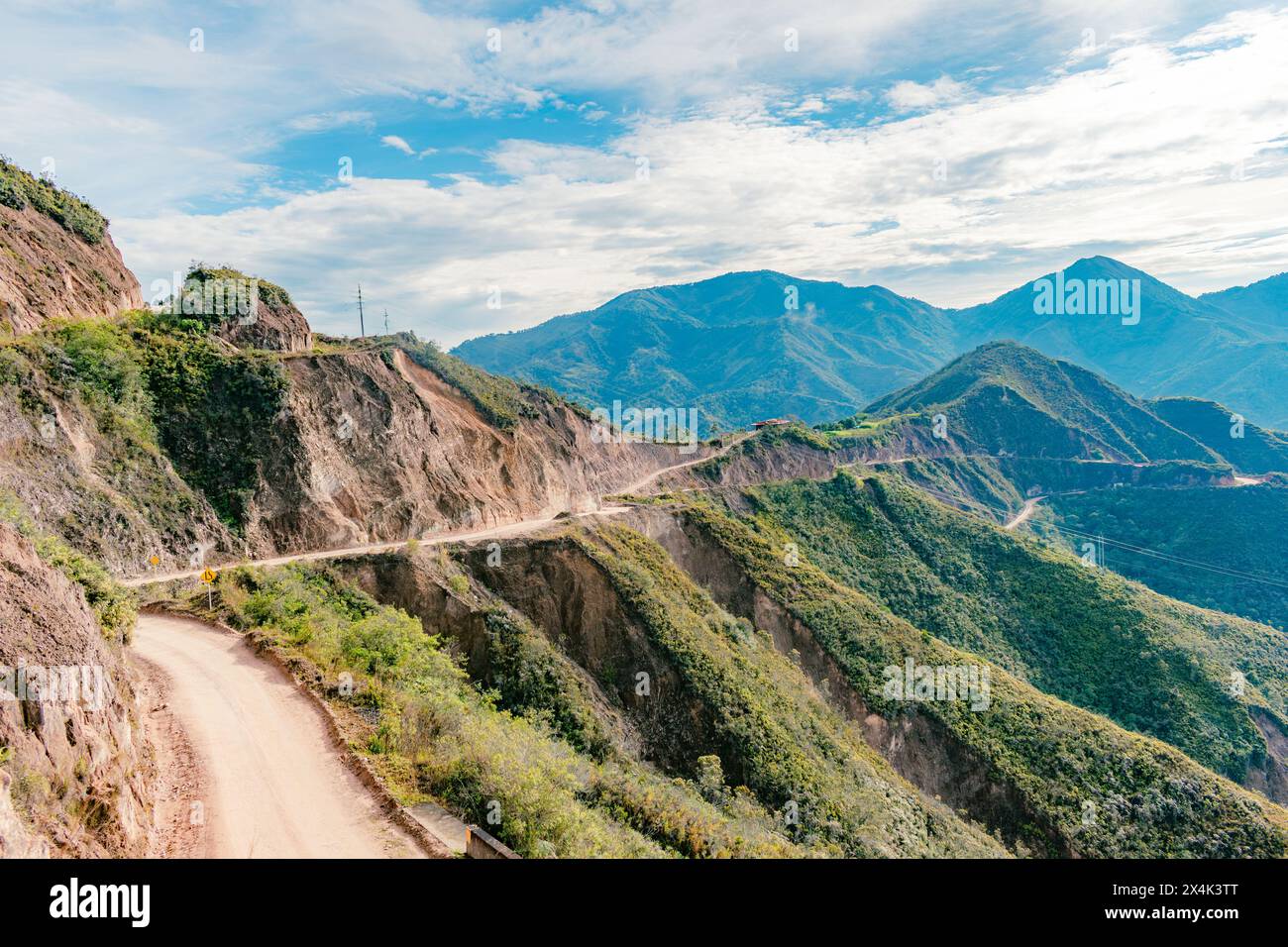 Paesaggio montuoso colombiano con una strada sterrata in una giornata di sole con cielo blu Foto Stock
