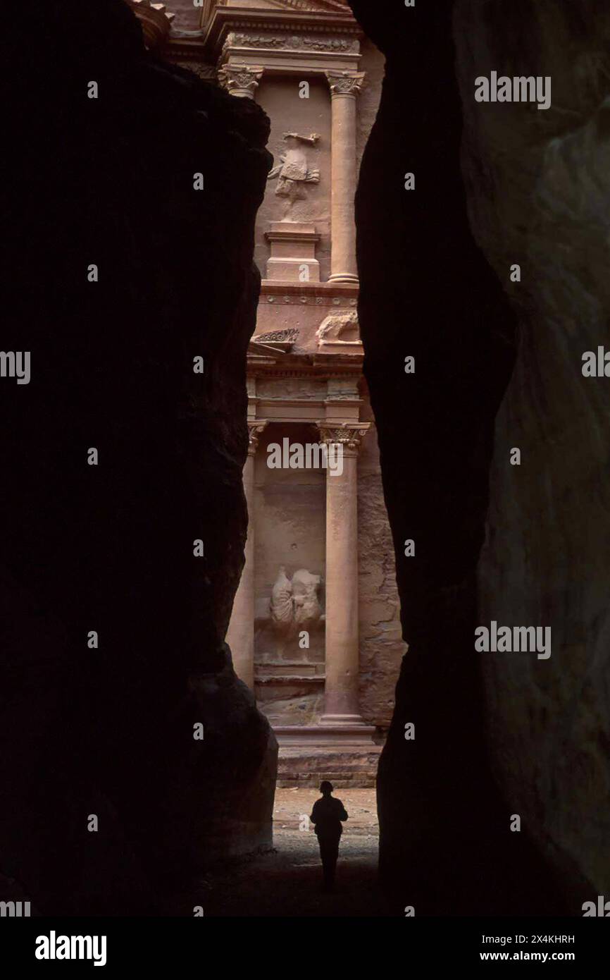 Persona che cammina nella fessura, Tesoro al-Khazneh, fessura Siq, Petra, Giordania Foto Stock