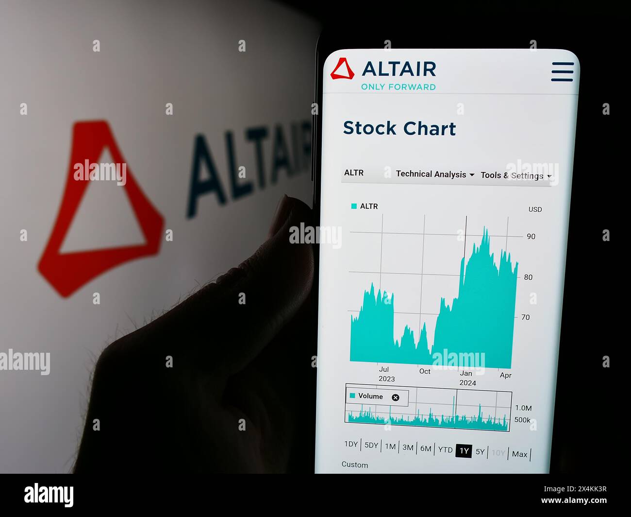 Persona che detiene lo smartphone con la pagina Web della società di software statunitense Altair Engineering Inc. Davanti al logo. Messa a fuoco al centro del display del telefono. Foto Stock
