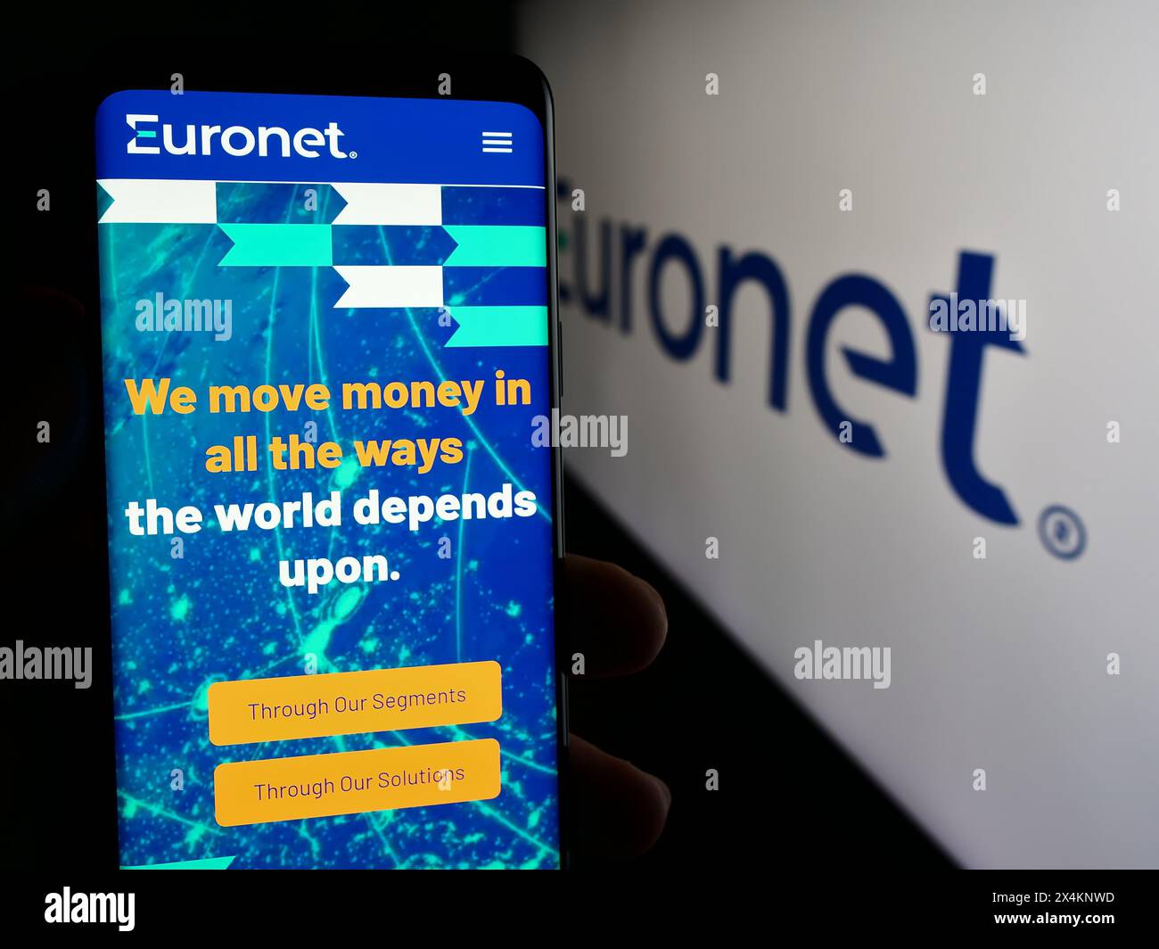 Persona che detiene un cellulare con pagina Web della società di pagamento statunitense Euronet Worldwide Inc. Davanti al logo aziendale. Messa a fuoco al centro del display del telefono. Foto Stock