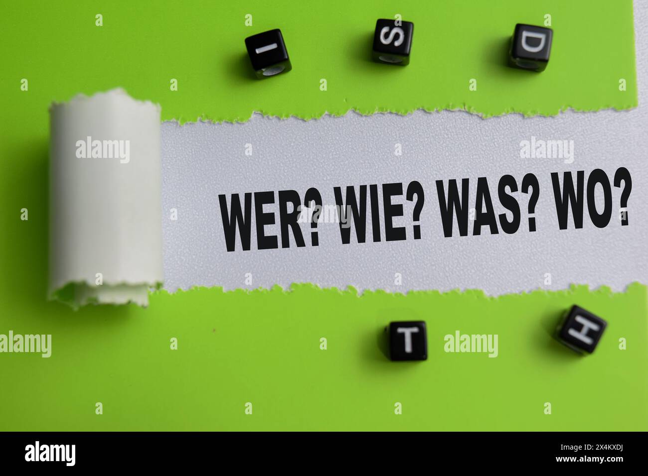 Concept of Wer? Wie? Was? Wo? Text written in torn paper. Foto Stock