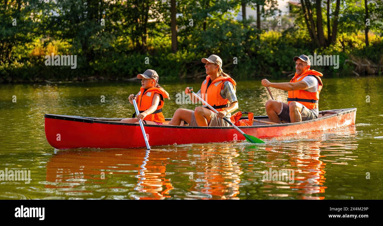 famiglia in canoa su un fiume in estate madre e figlia pagaiano sul fronte, padre sul retro in germania. Giro in kayak per tutta la famiglia. Natura selvaggia e acqua Foto Stock