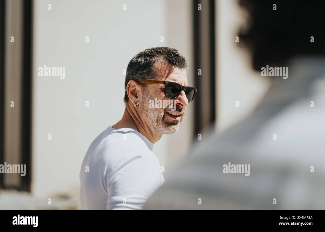 I professionisti aziendali intergenerazionali partecipano a una riunione strategica in un contesto urbano, discutendo progetti e crescita. Foto Stock