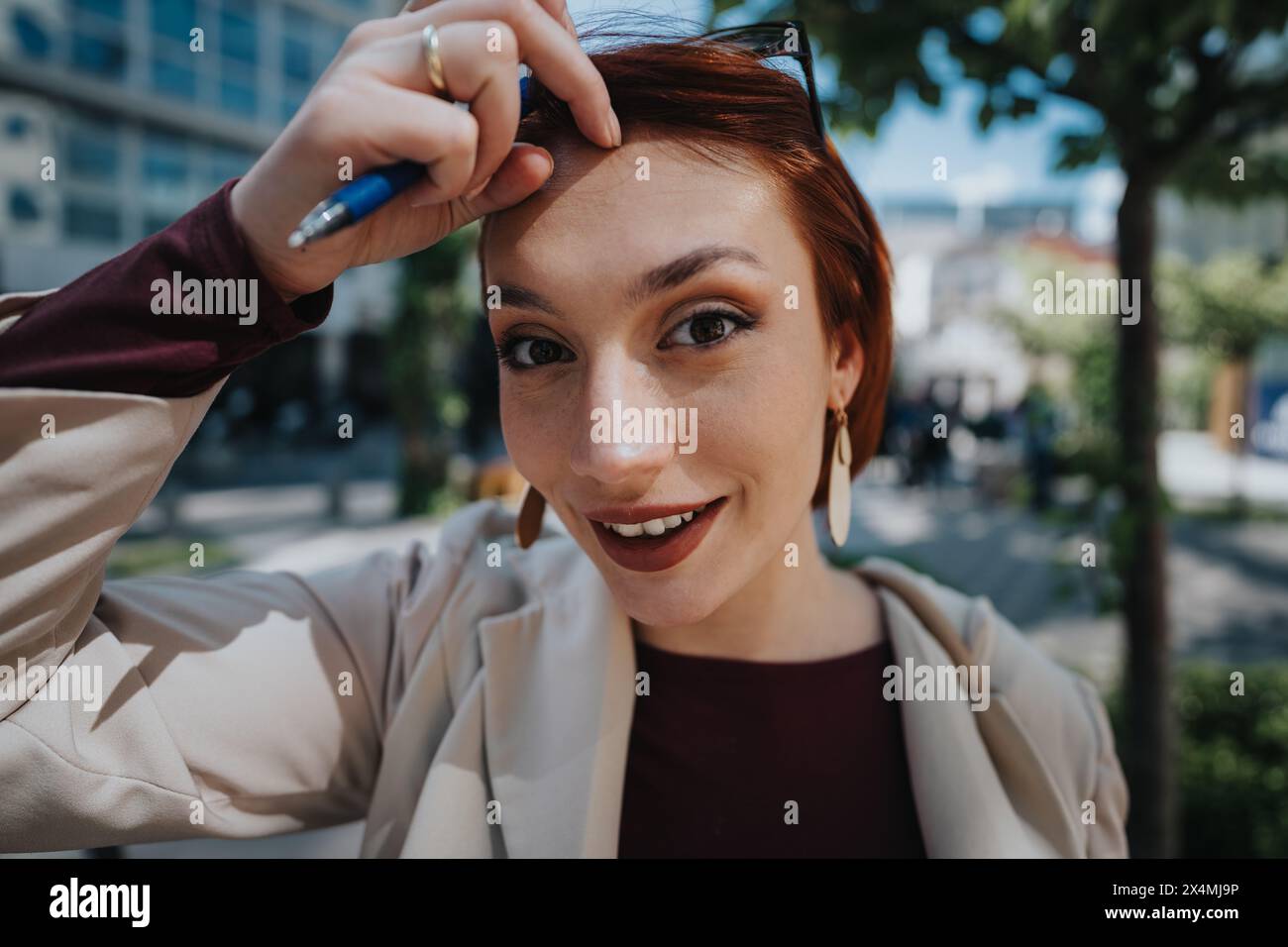 Giovane donna sicura di sé con un sorriso affascinante in un ambiente urbano Foto Stock