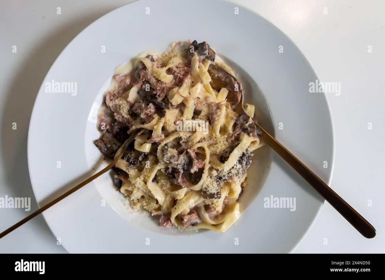 Tagliatelle in salsa panna con prosciutto e funghi Foto Stock