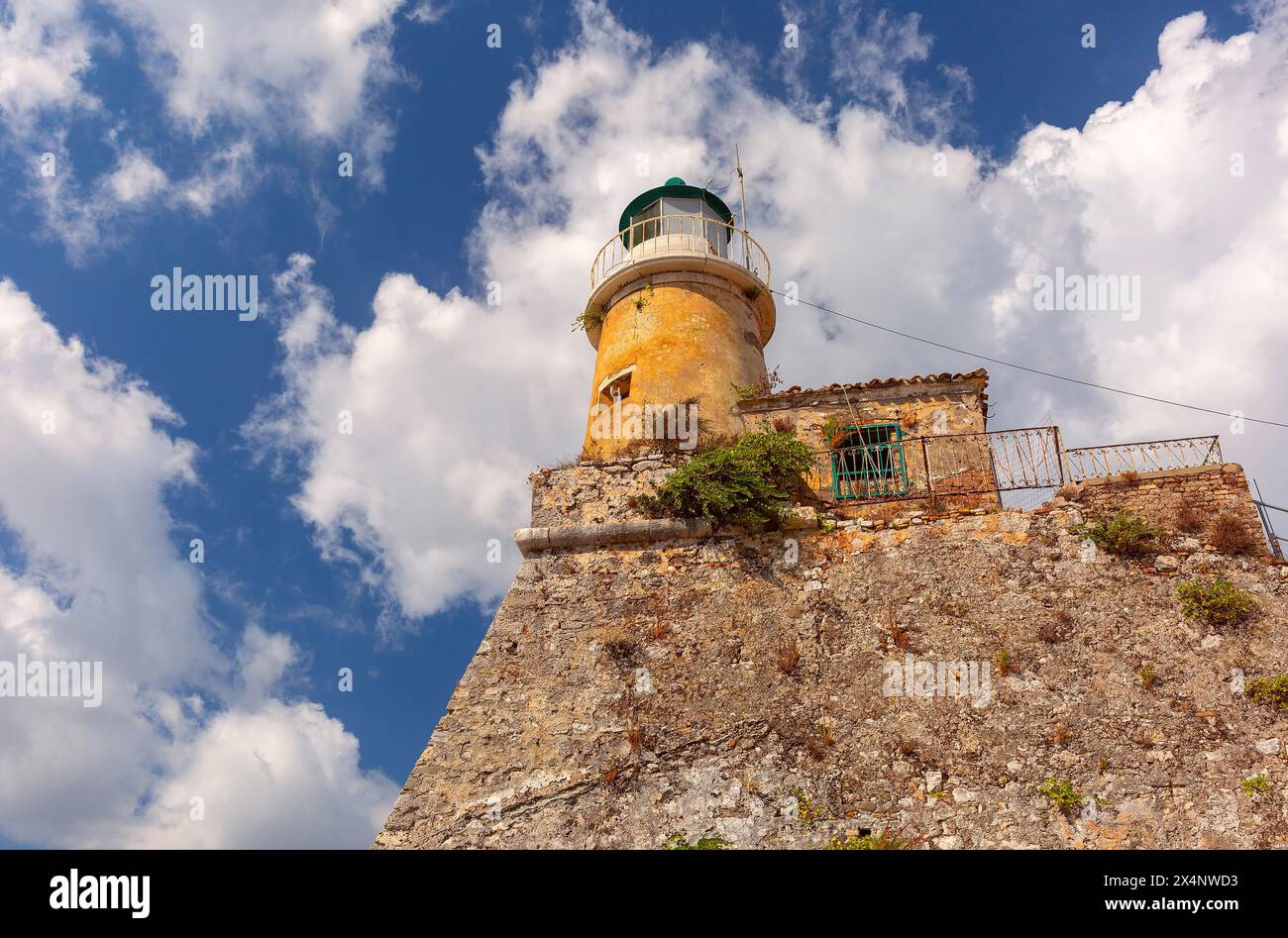 Faro arroccato in cima alla Fortezza Vecchia di Kerkyra, Corfù, Grecia, sotto un cielo nuvoloso Foto Stock
