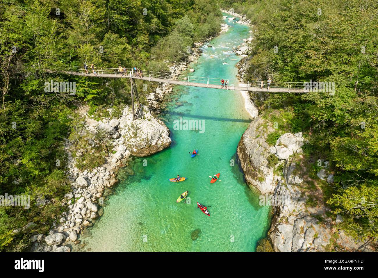 Un ponte sospeso attraversa le acque color smeraldo del fiume Soca in Slovenia Foto Stock