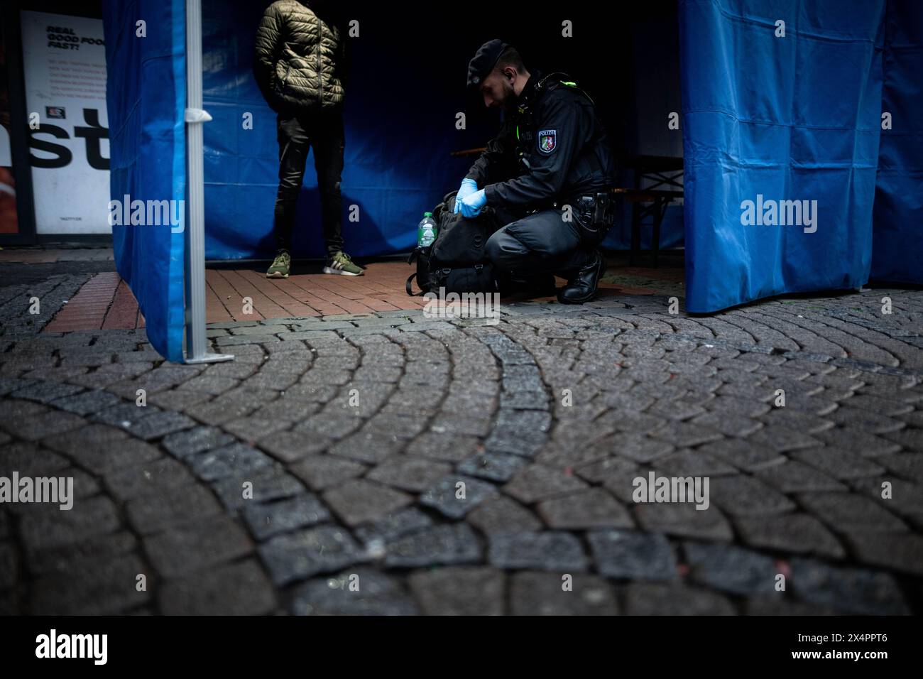 Duesseldorf, Germania. 4 maggio 2024. Gli agenti di polizia controllano i passanti nella città vecchia di Düsseldorf. Gli investigatori vogliono saperne di più sull'attività di influenti clan familiari nel settore della sicurezza e della guardia. Crediti: Fabian Strauch/dpa/Alamy Live News Foto Stock