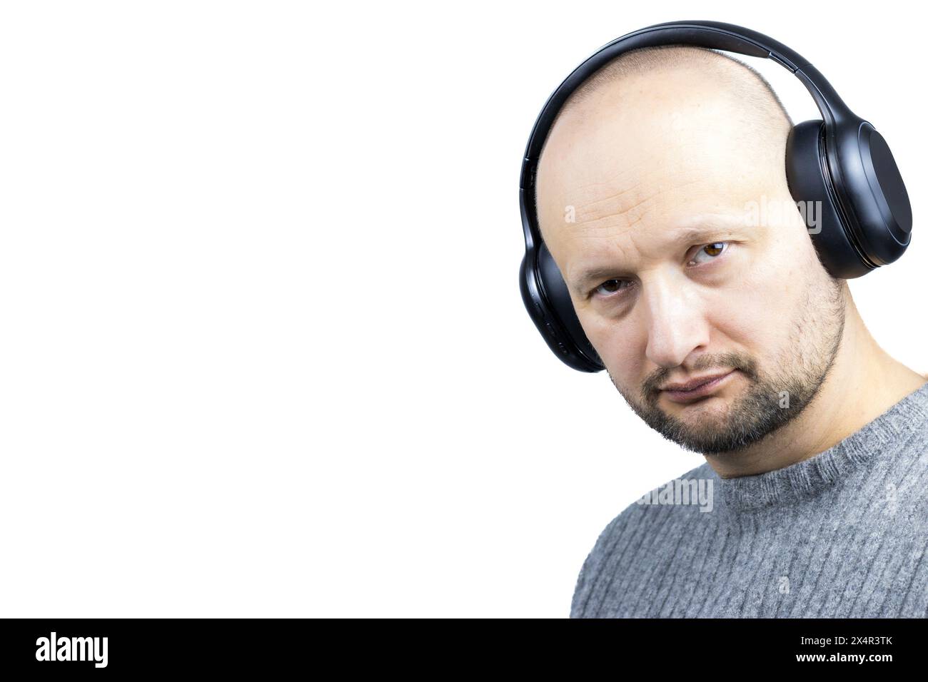 Questo è un ritratto accattivante di un uomo, su uno sfondo bianco. È rivestito di un maglione di lana grigia finemente lavorato a maglia Foto Stock