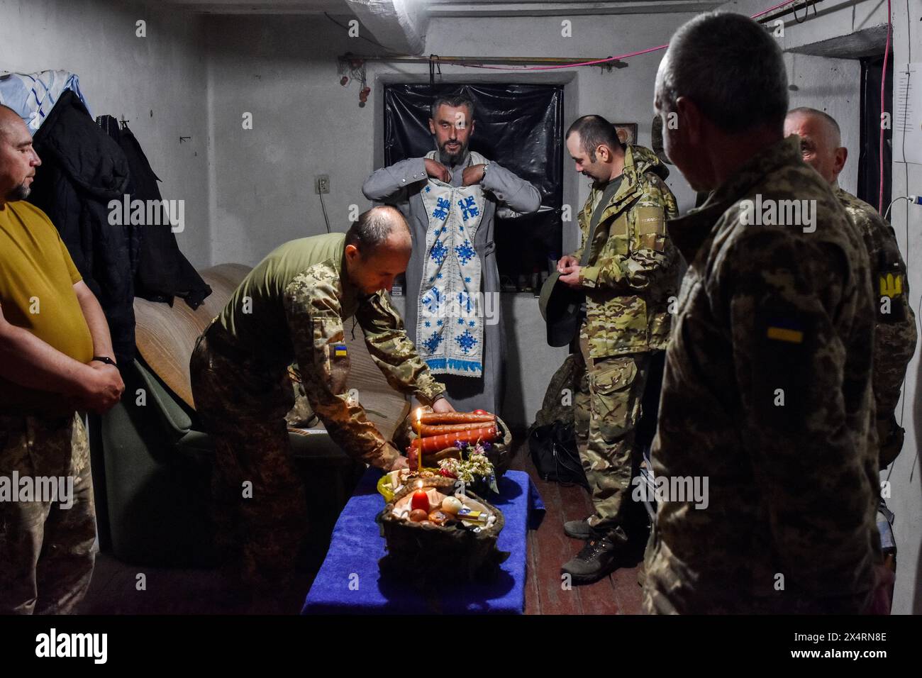 Un cappellano (centro) si prepara a benedire i soldati della 141a brigata di fanteria separata Ucraina alla vigilia di Pasqua vicino alla linea del fronte nella regione di Zaporizhzhia. Gli ucraini celebrano la Pasqua ortodossa, e i militari delle forze armate ucraine aderiscono alle tradizioni nazionali anche in prima linea. Il servizio di sicurezza dell'Ucraina avverte dei tentativi della Russia di destabilizzare la situazione in Ucraina attraverso provocazioni, tra cui il coinvolgimento di agenti a commettere provocazioni interreligiose e aggiustare il fuoco ostile sulle infrastrutture civili durante le celebrazioni di Pasqua. (Foto di Andriy Andriyenko/SOPA i Foto Stock