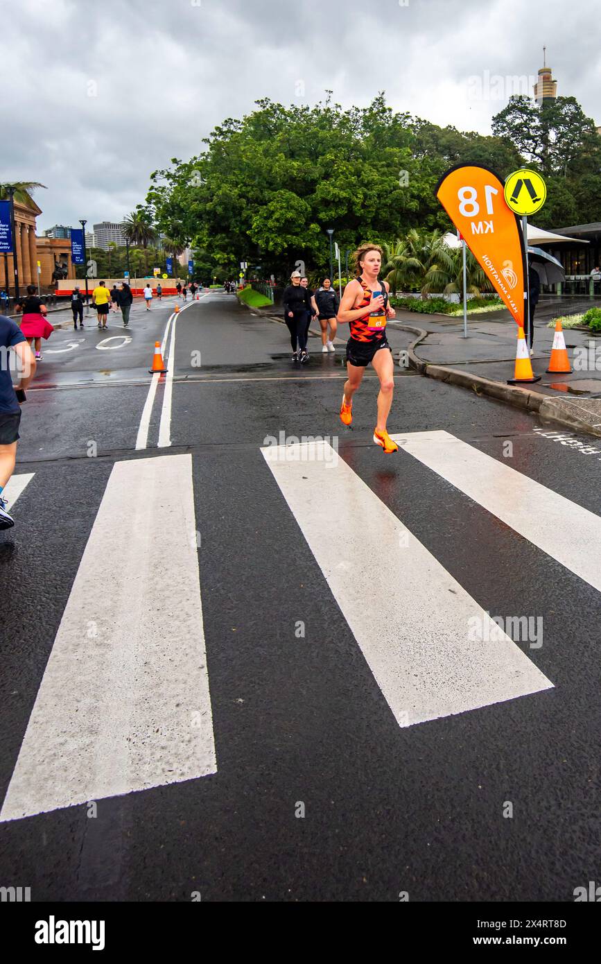 Sydney Australia 05 maggio 2024 HOKA Runaway Sydney Half Marathon 2024: Corsa in costante pioggia, il favorito, Edward Goddard (#67) supera il traguardo dei 18 chilometri per vincere la mezza maratona di Sydney 2024. Correndo qui vicino alla Art Gallery of New South Wales, Edward ha vinto la gara in un tempo di 1 ora e 5 minuti e 40 secondi (01:05:43). Abigail Nordberg (#61) ha vinto l'evento femminile con un tempo di 1 ora 14 minuti e 35 secondi. Crediti: Stephen Dwyer / Alamy Live News Foto Stock