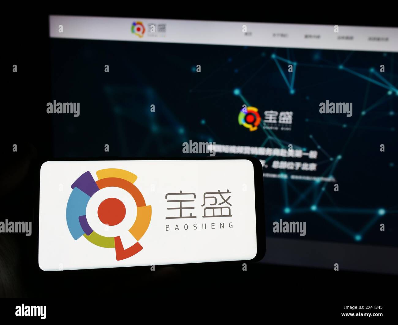 Persona che detiene uno smartphone con il logo della società cinese Baosheng Media Group Holdings Limited davanti al sito web. Mettere a fuoco il display del telefono. Foto Stock