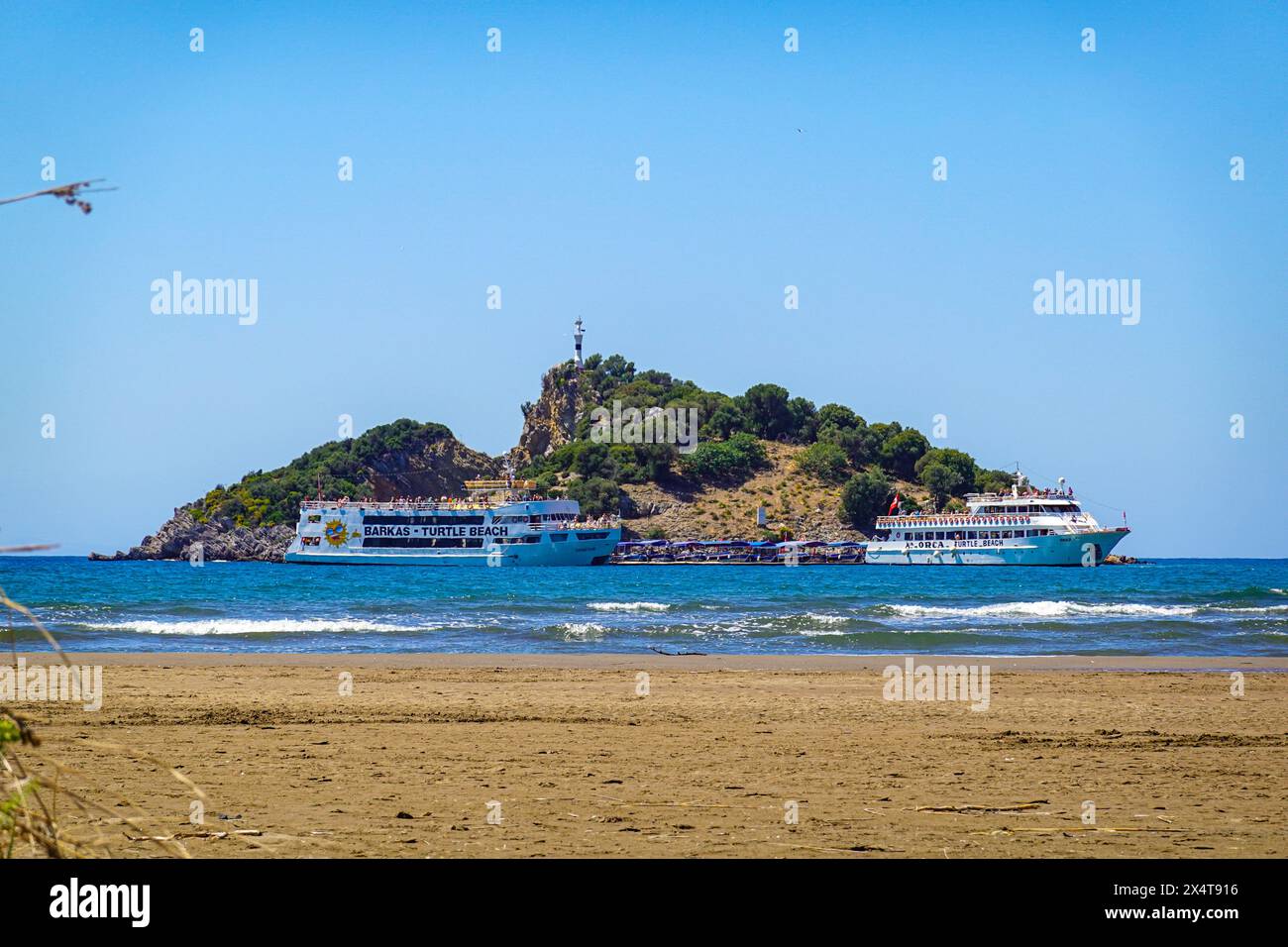 Barche turistiche che arrivano alla spiaggia di Iztuzu, Turtle Beach, presso la popolare destinazione turistica di Dalyan, provincia di Mugla, Turchia Foto Stock