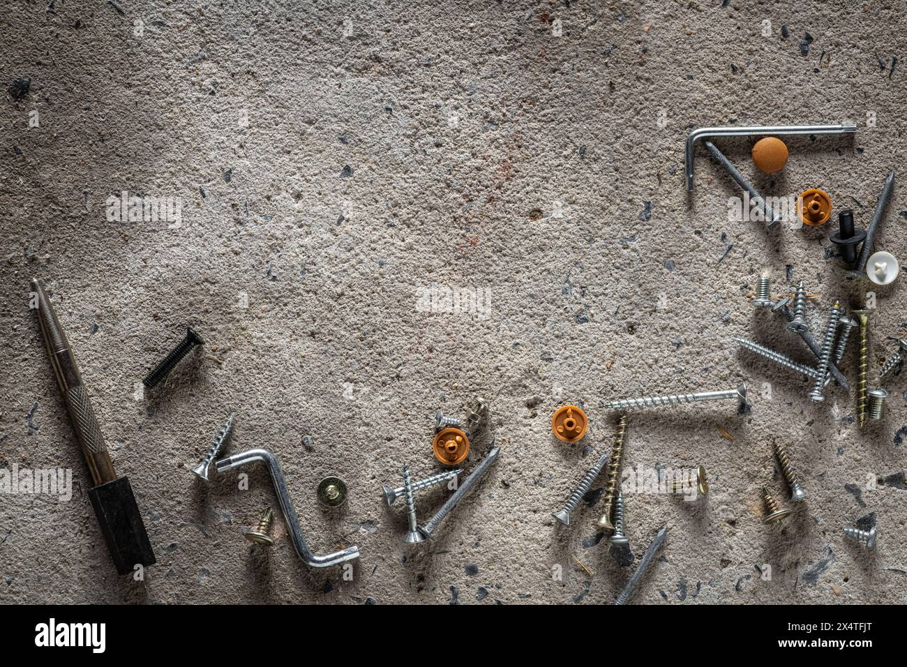 Vite, chiodo su fondo in calcestruzzo. Primo piano di viti e chiodi sul pavimento in cemento con spazio di copia. Foto Stock