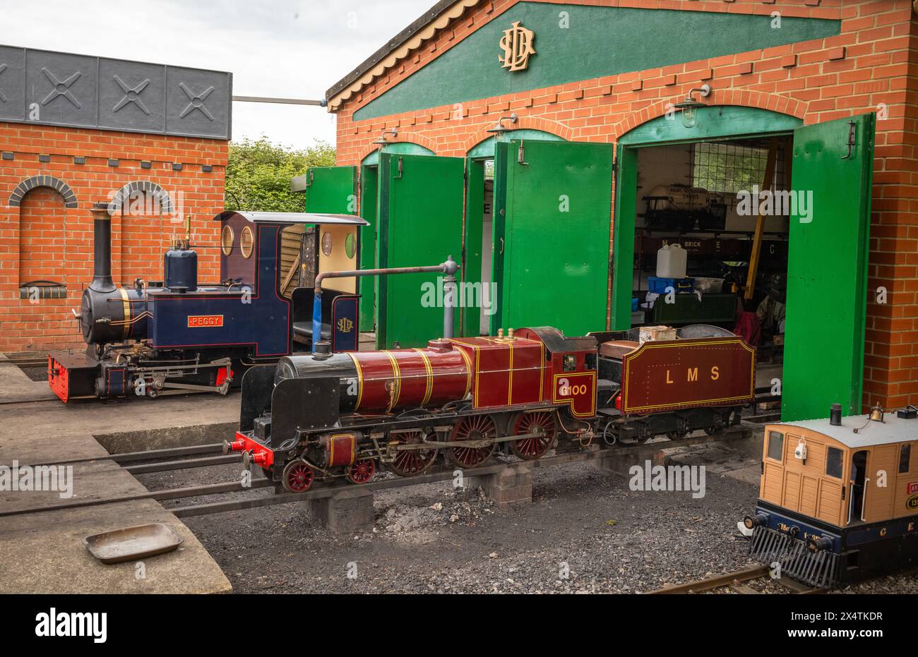 Locomotive a vapore in miniatura all'esterno del capannone motore presso South Downs Light Railway, Pulborough, Regno Unito Foto Stock