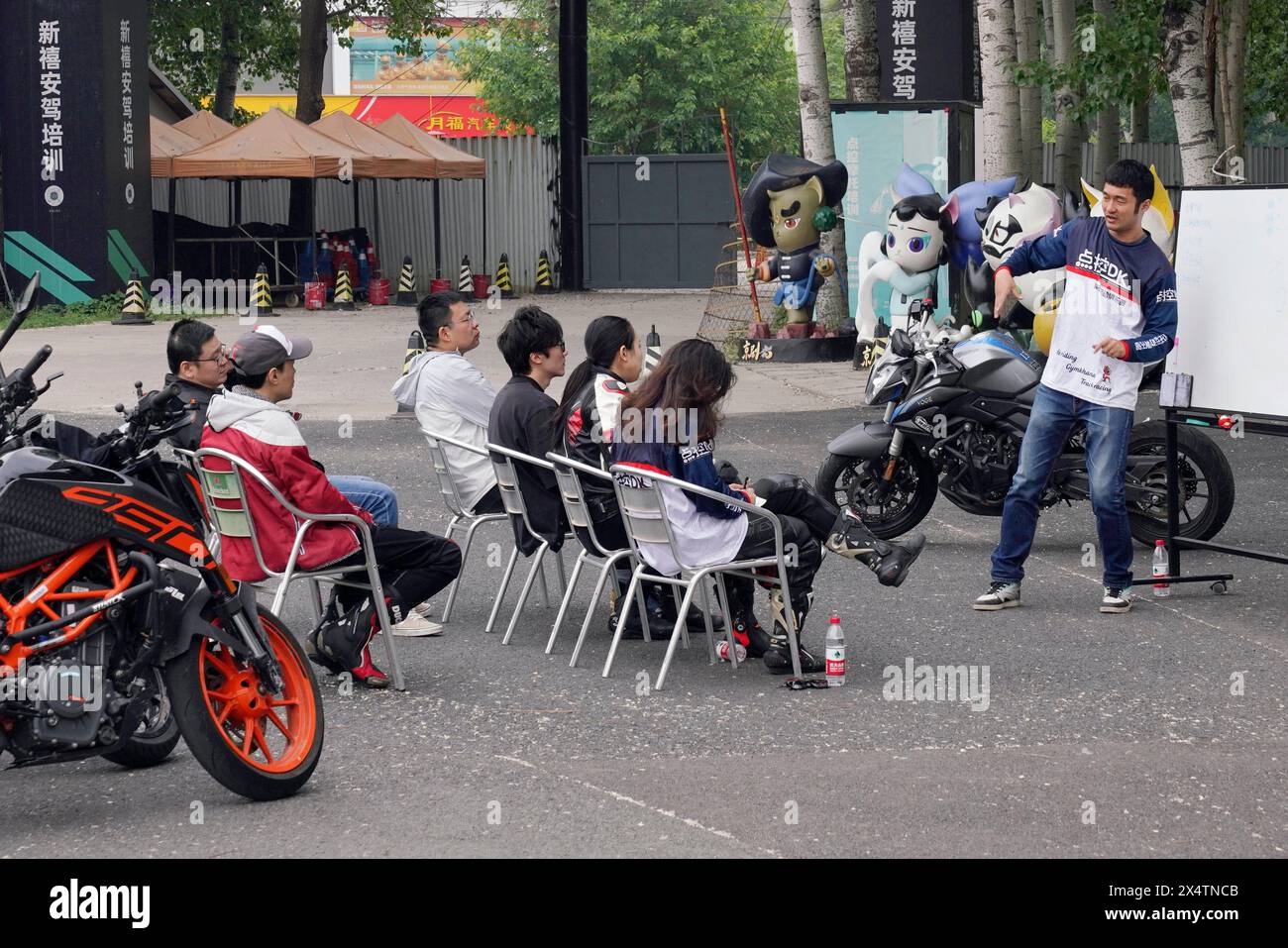 (240505) -- PECHINO, 5 maggio 2024 (Xinhua) -- gli appassionati di motori ricevono una formazione teorica in un cinema drive-in nel distretto di Chaoyang, Pechino, capitale della Cina, 4 maggio 2024. In un cinema drive-in nel quartiere di Chaoyang, Pechino, quando non ci sono film in riproduzione durante il giorno, decine di motociclette ruggiscono sulla piazza aperta. Man mano che le motociclette diventano sempre più popolari tra i giovani, sempre più persone scelgono di perfezionare le proprie abilità di guida prima di mettersi in viaggio per provare l'emozione. Wang Lu, un allenatore di equitazione, ha detto che oltre 2.000 persone hanno ricevuto formazione su questo sito, Foto Stock