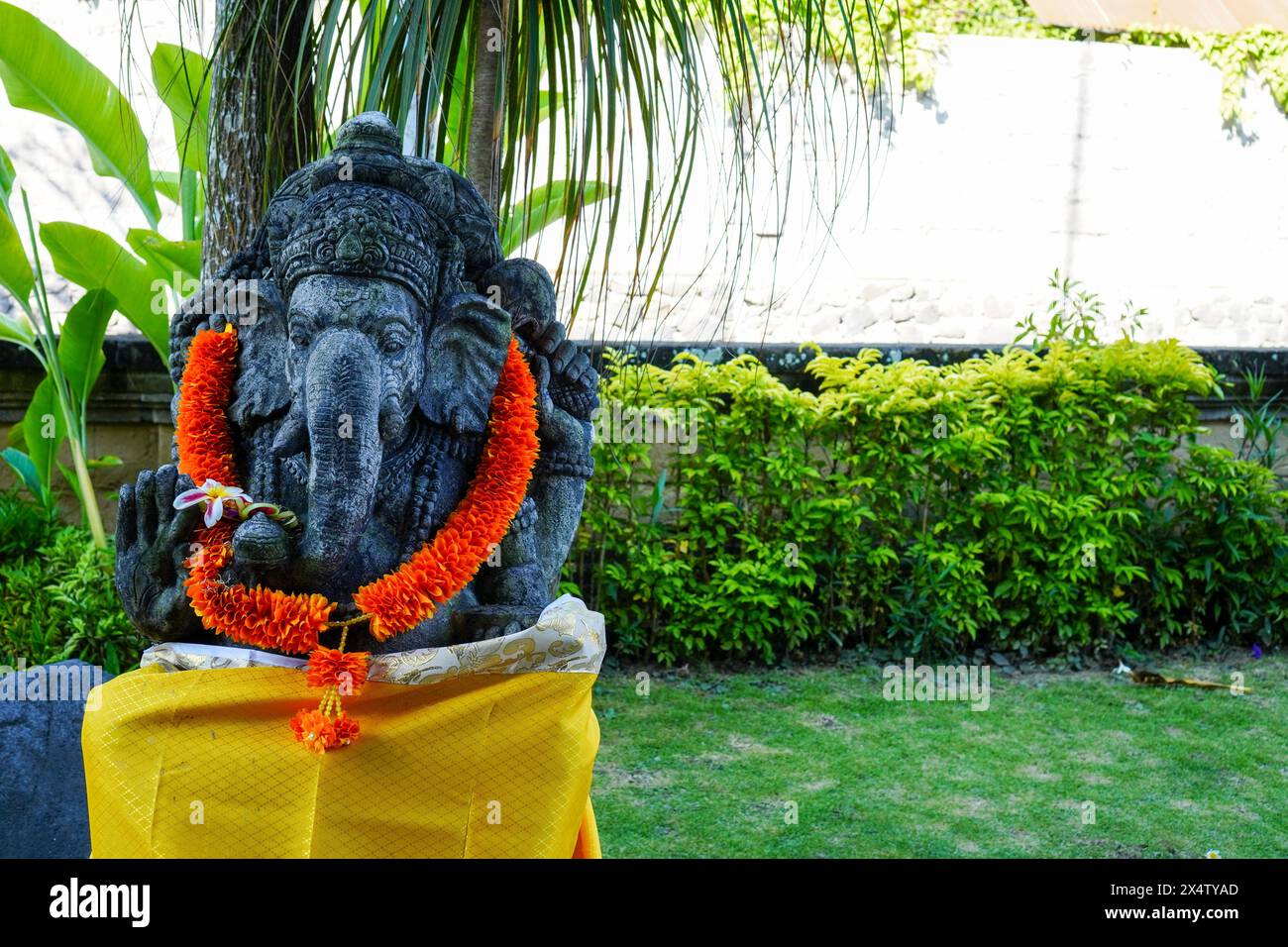 Statua del Signore Ganesha con ghirlanda gialla, una tradizione delle credenze religiose indù di Bali Foto Stock