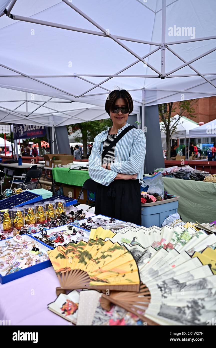 Un venditore cinese di occhiali si trova di fronte ai suoi prodotti al Chinatown Festival di Calgary, AB Canada Foto Stock