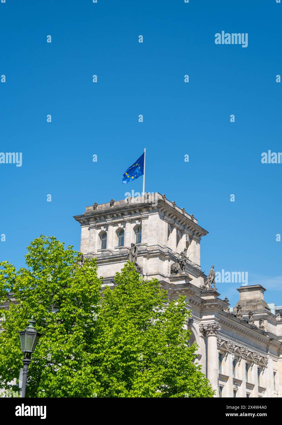 Bandiera dell'Unione europea che sventola sopra l'edificio del Parlamento tedesco, simboleggiando l'unità, la cooperazione e i valori condivisi all'interno dell'Unione europea Foto Stock