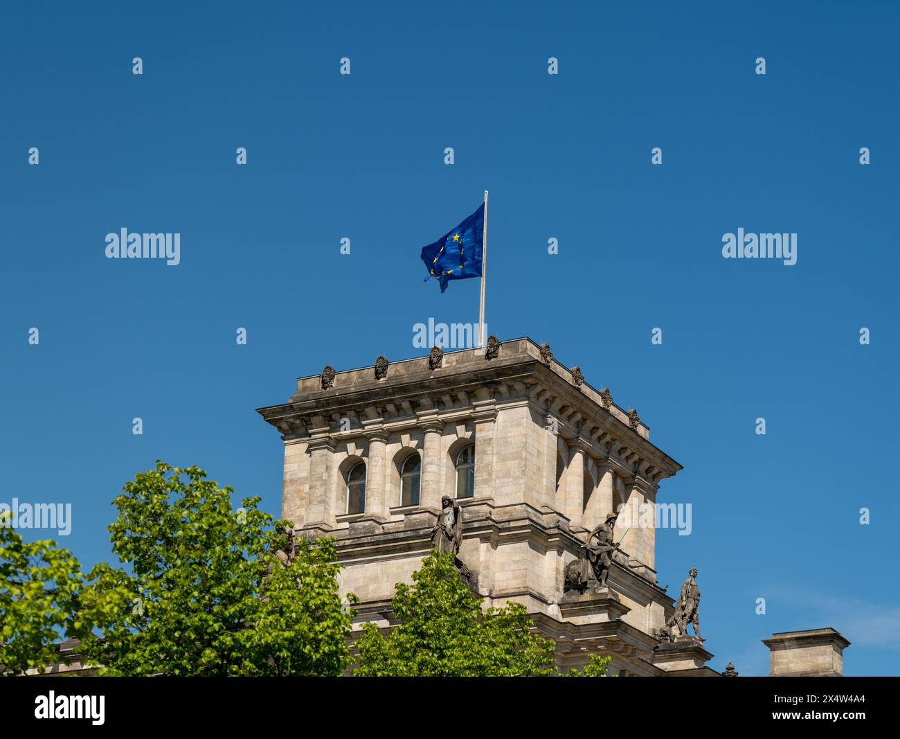 Bandiera dell'Unione europea che sventola sopra l'edificio del Parlamento tedesco, simboleggiando l'unità, la cooperazione e i valori condivisi all'interno dell'Unione europea Foto Stock