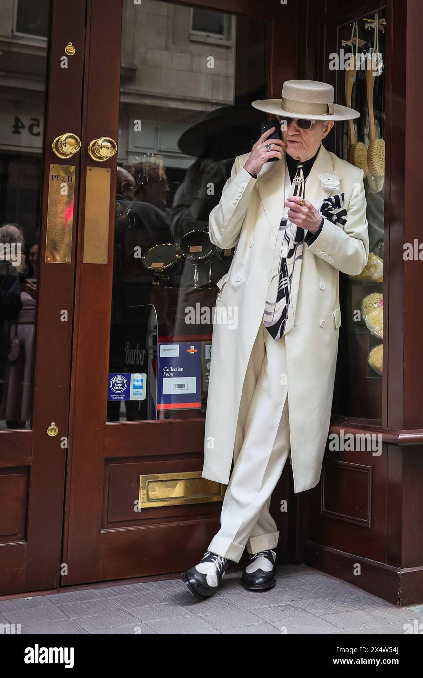 Londra, Regno Unito. 5 maggio 2024. Un gentiluomo benestante, ampiamente conosciuto come 'Soho George', si rilassa all'ingresso. Un gruppo di pulcini, cappelle e danze vestiti in modo elegante prendono parte all'annuale Grand Flaneur Walk, iniziando accanto alla statua di Beau Brummell in Jermyn Street e poi passeggiando per l'area di St James di Londra. Crediti: Imageplotter/Alamy Live News Foto Stock