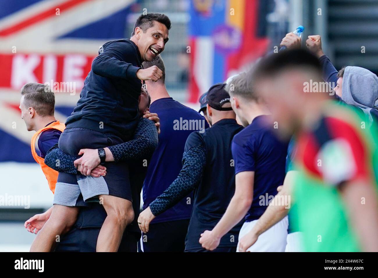 Wiesbaden, Germania. 5 maggio 2024. Calcio: Bundesliga 2, SV Wehen Wiesbaden - Holstein Kiel, giorno 32, BRITA-Arena. L'allenatore di Kiel Marcel Rapp (l) celebra la vittoria con lo staff e i giocatori. Credito: Uwe Anspach/dpa - NOTA IMPORTANTE: in conformità con i regolamenti della DFL German Football League e della DFB German Football Association, è vietato utilizzare o far utilizzare fotografie scattate nello stadio e/o della partita sotto forma di immagini sequenziali e/o serie di foto video./dpa/Alamy Live News Foto Stock