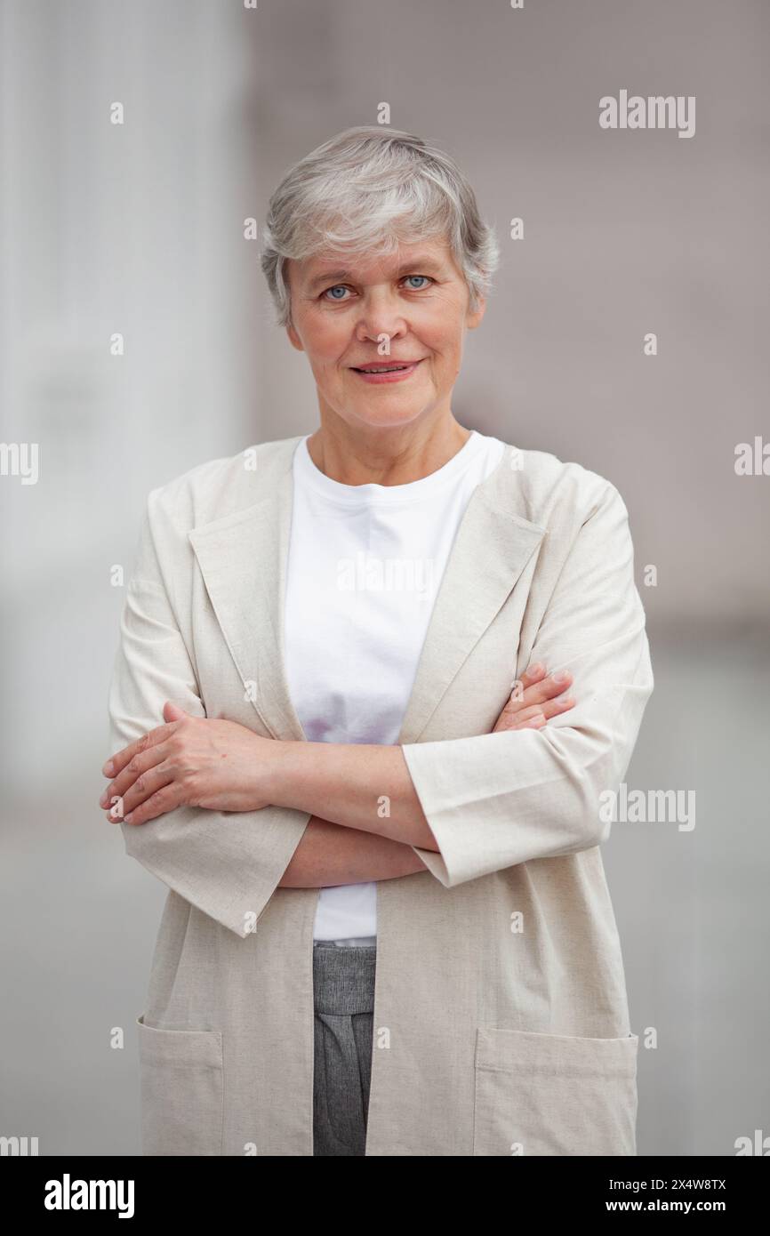 Bella donna professionale senior, felice fiducioso imprenditore modello positivo in piedi all'aperto in strada, donna matura con corte ha grigio Foto Stock