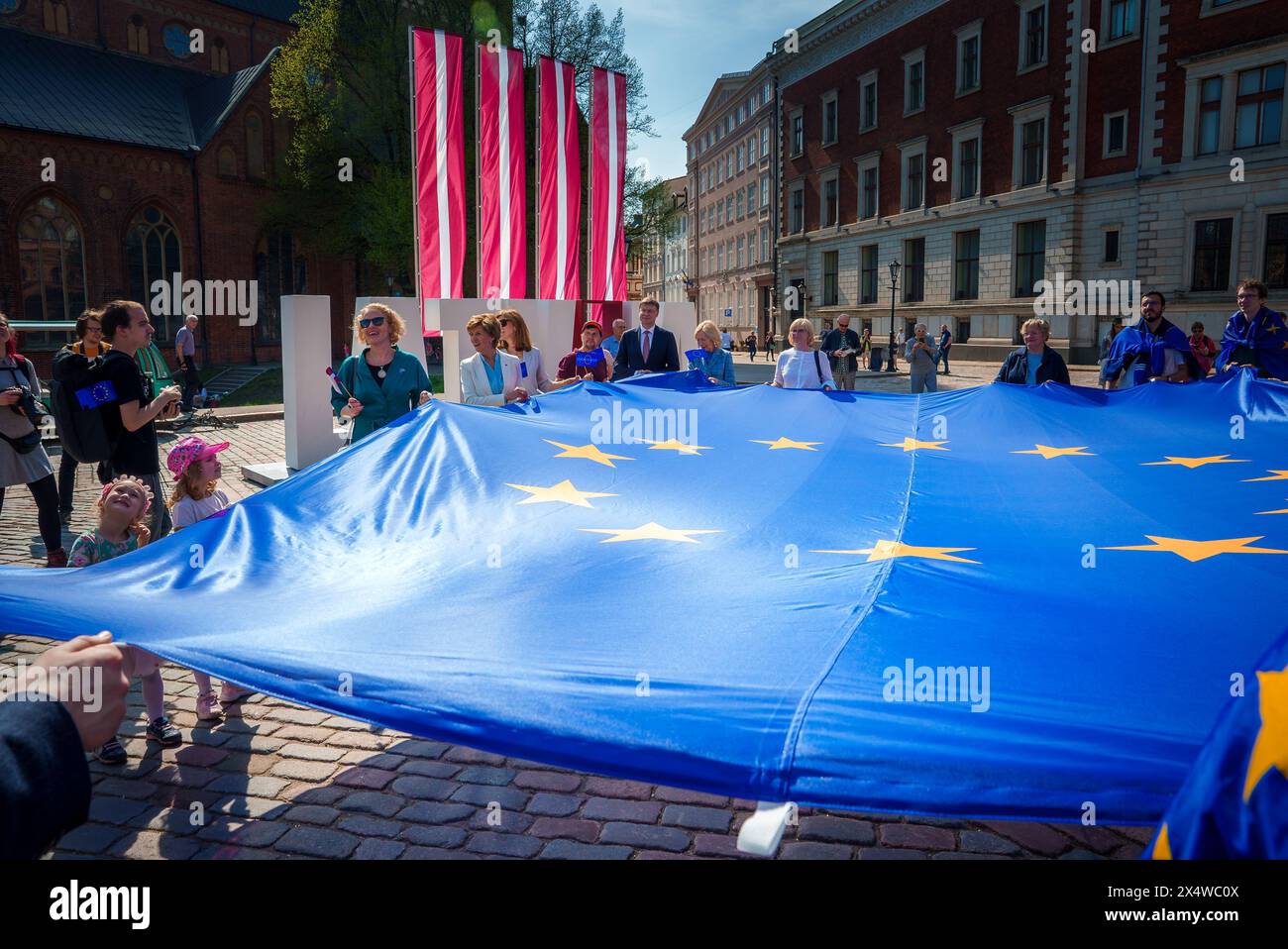 Celebrazione dell'Unione europea a riga, in Lettonia, vivace scena con bandiere e persone Foto Stock