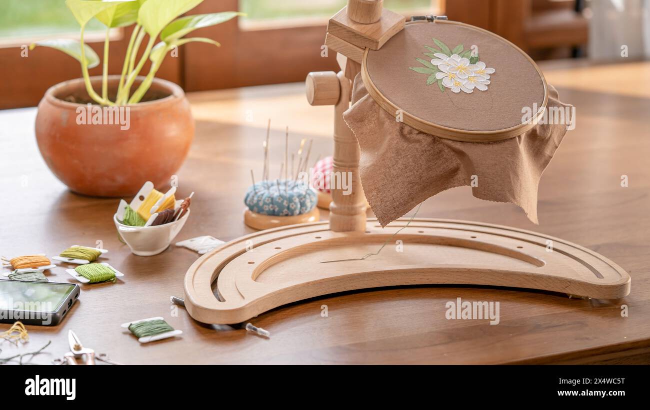 Dalla spazzola alla cucitura: Combinazione di tessuto verniciato con fiori ricamati a mano Foto Stock