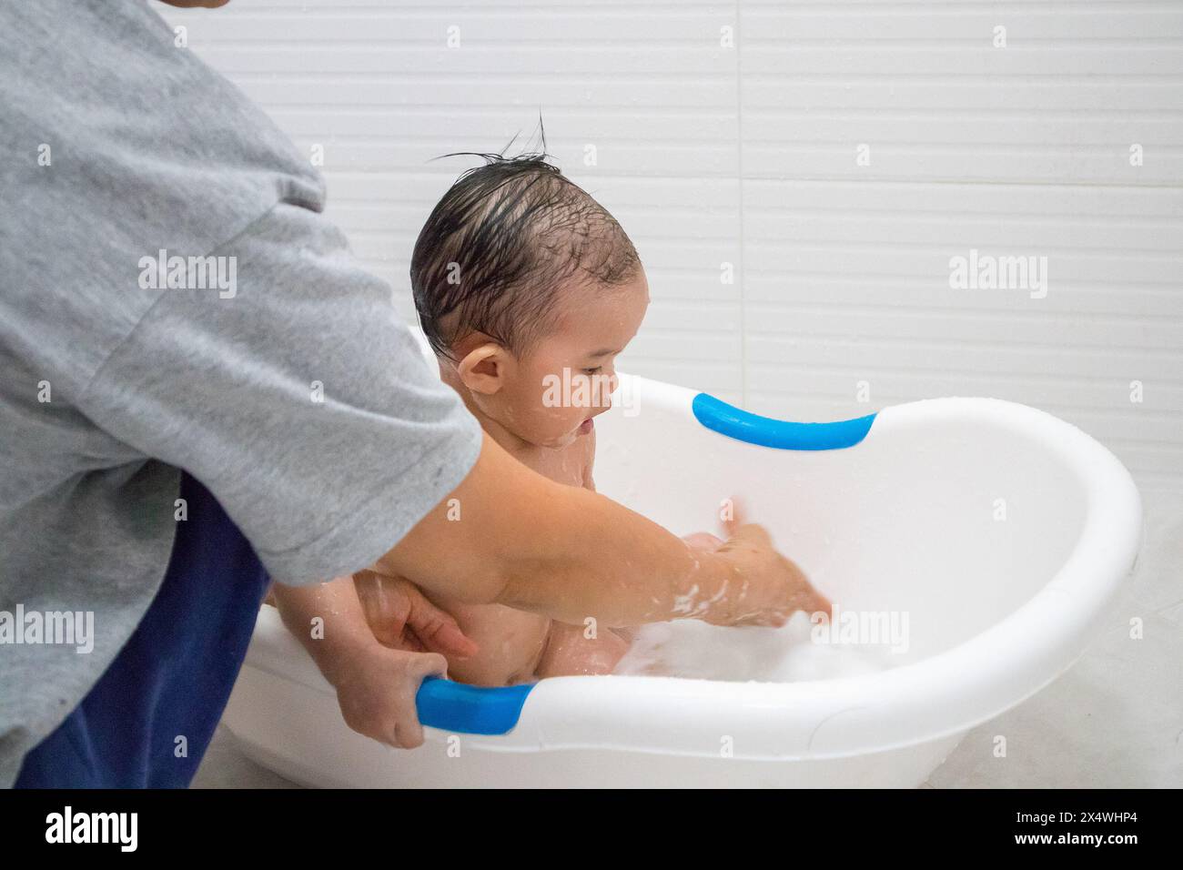 Felice bambina asiatica che fa il bagno Foto Stock