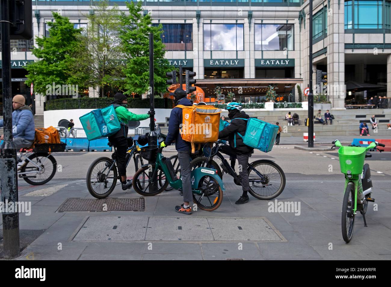 Deliveroo e Just Eat Courier Couriers lavoratori uomini riders su cibo consegna biciclette Liverpool Street City of London Inghilterra Regno Unito 2024 KATHY DEWITT Foto Stock