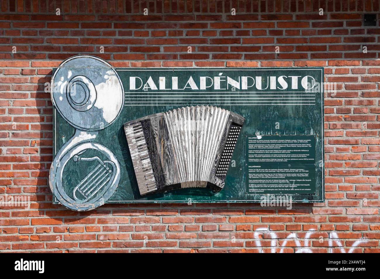 Cartello o rilievo in legno su un muro di mattoni rossi presso il Parco Dallapé nel quartiere Vallila di Helsinki, Finlandia Foto Stock