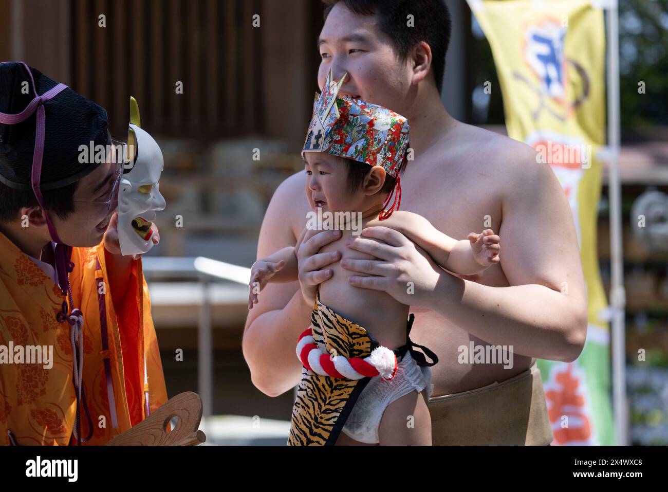 Il prete shintoista cerca di far piangere un bambino con la maschera di un demone durante l'evento Nakizumo. Nakizumo, in inglese chiamato 'Crying Baby Festival' è fatto in nome della benedizione del bambino come "naku ko wa sodatsu" che si traduce in "i bambini piangono crescere", il che significa che i bambini che piangono crescerebbero forti e sani. Nakizumo serve anche a scacciare gli spiriti maligni e viene eseguito all'interno dei santuari shintoisti. Oltre alla partita di pianto ci sono altre attività che vengono svolte dalle famiglie, come le opportunità fotografiche con veri lottatori di sumo, cerimonie di preghiera e impronte di mano del bambino. (Foto di Stanislav Kogiku/SOPA Images/ Foto Stock