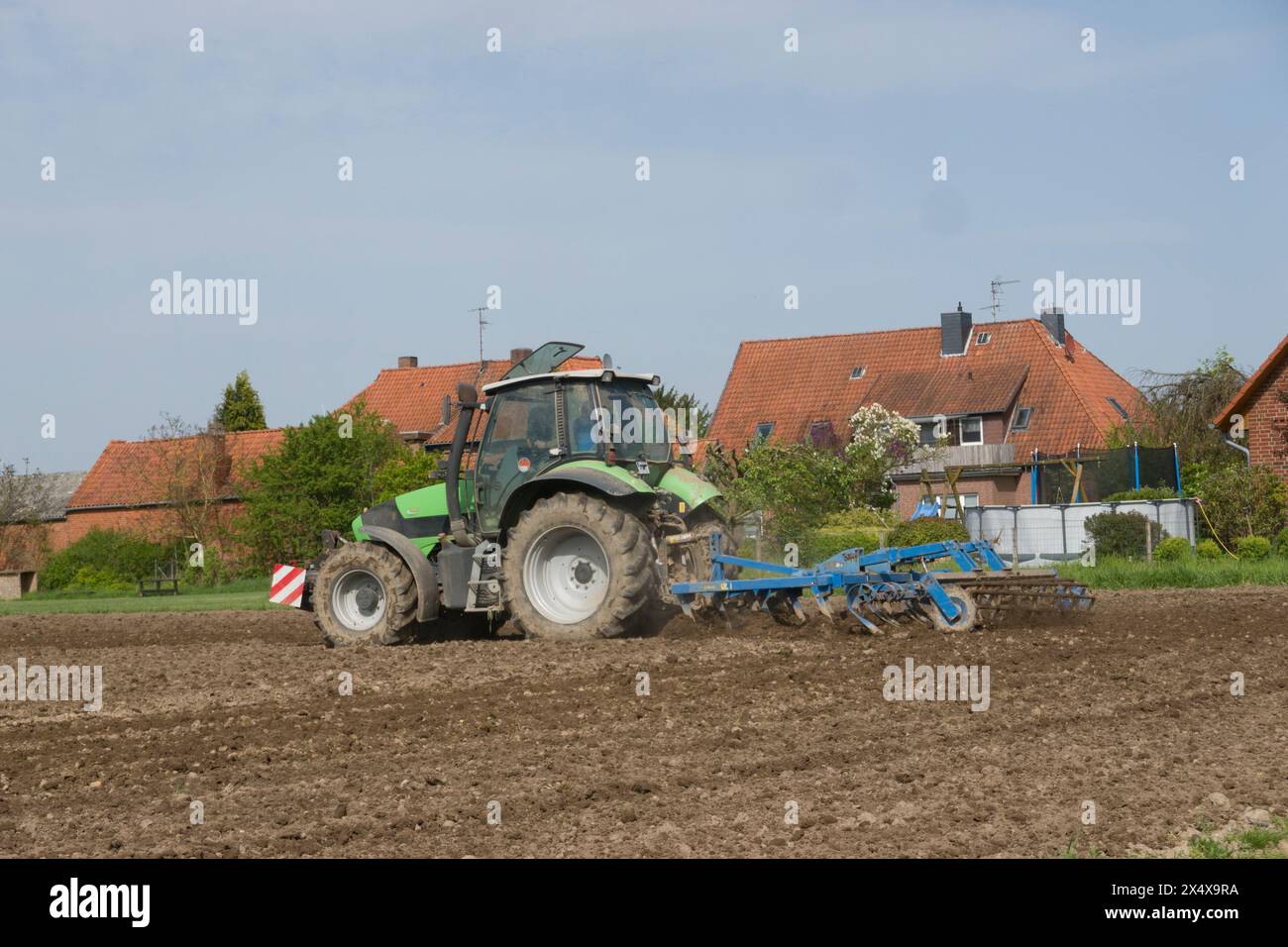 Landwirt beim Grubbern eines Feldes, Niedersachsen, Deutschland, Oetzen Foto Stock