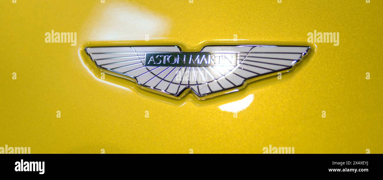 Dettaglio dell'emblema Aston Martin su un cappuccio giallo di un'auto Foto Stock